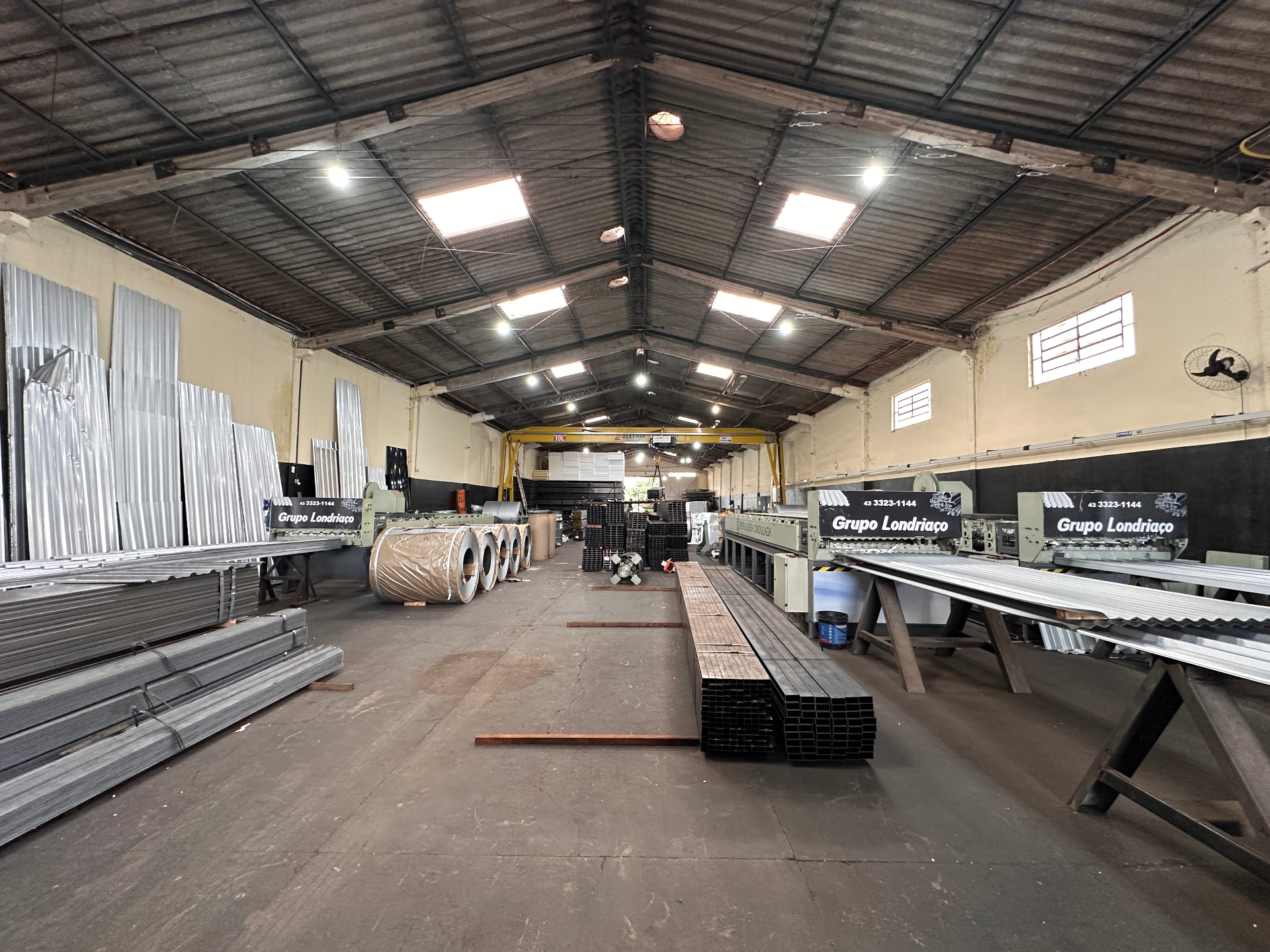 Vista ampla do estoque interno com máquinas e materiais da HM Metais.